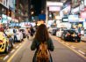 Young woman traveler traveling into Mongkok street market at night in Hong Kong China