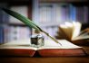 quill-pen-on-an-old-book-in-a-library-P4GNDL6